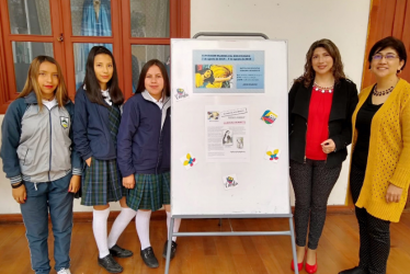 Tres estudiantes y dos maestras exponiendo su trabajo